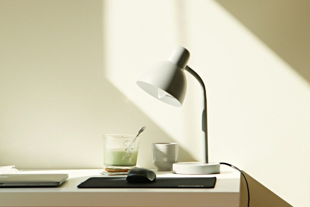At home work desk with Matcha Tea, Mouse, Laptop and Lamp.