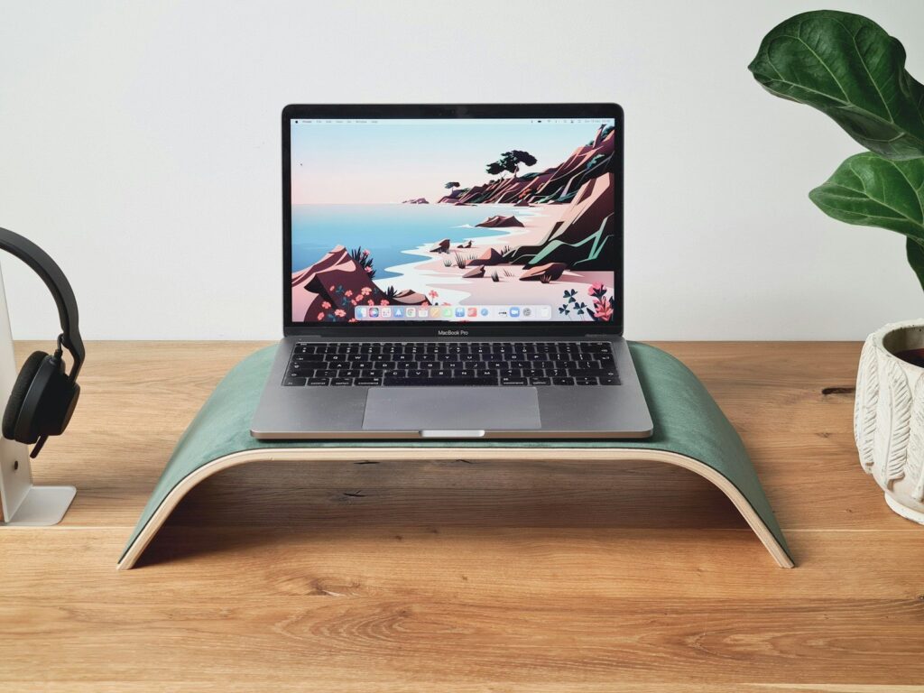 a laptop computer sitting on top of a wooden desk